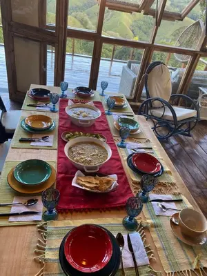 a wooden table with plates and bowls of food on it at MaRaVillas DR in the mountains excellent location in Jarabacoa