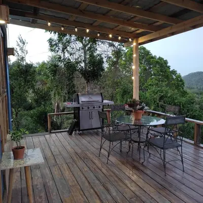 a patio with a grill and a table on a deck at MaRaVillas DR in the mountains excellent location in Jarabacoa