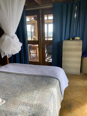 a bedroom with blue walls and a bed with a white bedspread at MaRaVillas DR in the mountains excellent location in Jarabacoa