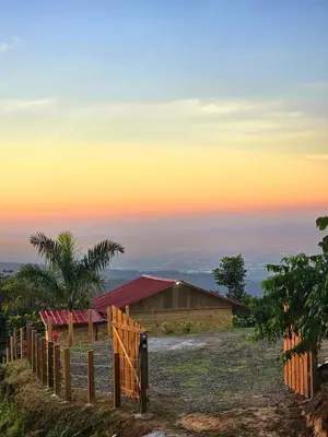 a fence on a hill with a sunset in the background at Mountain refuge - Cabin with wonderful views! in La Búcara