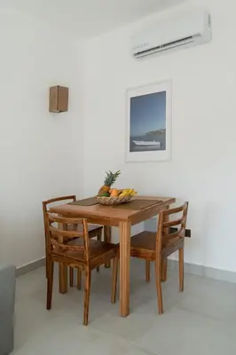 a wooden table with chairs and a bowl of fruit on it at La Anshihi in Las Terrenas
