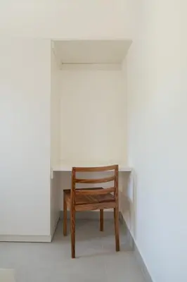 a wooden chair sitting in front of a white desk at La Anshihi in Las Terrenas