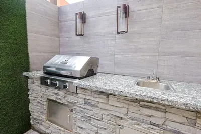 a kitchen counter with a grill and a sink at Elegant Centric Apt Near all in Santo Domingo