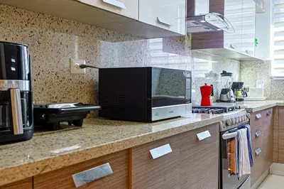a kitchen with a counter top with a microwave at Elegant Centric Apt Near all in Santo Domingo