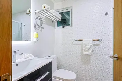 a white bathroom with a toilet and a sink at Elegant Centric Apt Near all in Santo Domingo