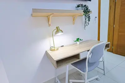 a desk with a lamp and a chair in a room at Elegant Centric Apt Near all in Santo Domingo