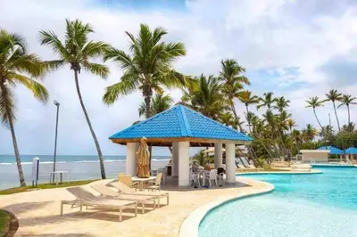 a pool at a resort with chairs and a gazebo at Cozy Beach Condo Great Views in Guayacanes