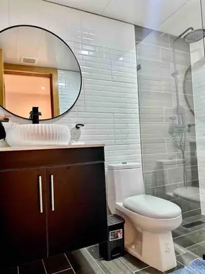 a bathroom with a toilet and a sink and a mirror at Cozy Beach Condo Great Views in Guayacanes