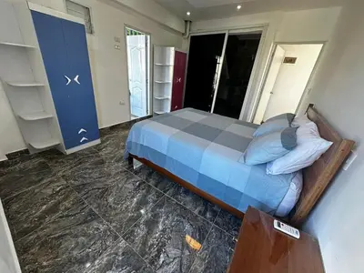 a bedroom with a bed with a blue comforter at Apart-hotel Central in Las Terrenas