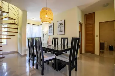 a dining room with a black table and chairs at Pro Cab Paradise Condos Cabarete in Cabarete