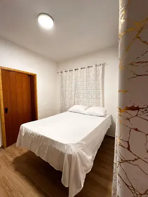 a bedroom with a white bed and a window at Residencial Fe y Esperanza in Pedernales