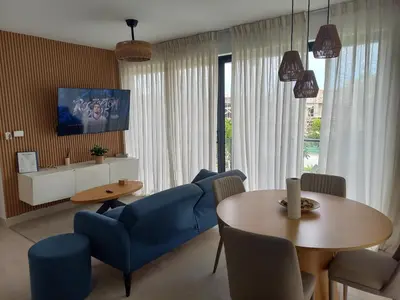a living room with blue chairs and a table at Apartamento en Vista Cana in Batey San Germán