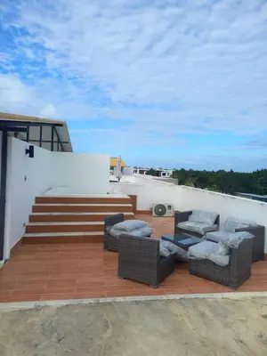 a patio with couches and chairs on a roof at Apartamento en Vista Cana in Batey San Germán