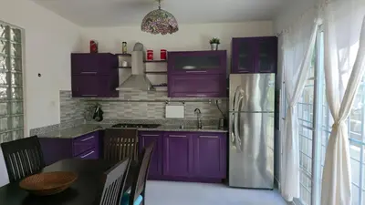 a kitchen with purple cabinets and a refrigerator at Acogedora Casa privada in Bayahibe