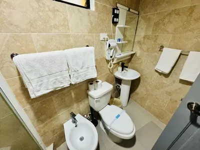 a bathroom with a white toilet and a sink at Central, a 5 Minutos de Playa, AC, Piscina, Cómodo, Bares, Rest in Sosúa