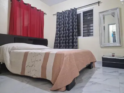 a bedroom with a bed and a red curtain at Flor D Loto in Bejuquero