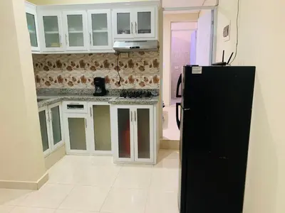 a kitchen with white cabinets and a black refrigerator at Apartamento Familiar 7 in Colorado