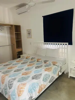 a bedroom with a white bed with a colorful comforter at El patio de Lucia, center 4 people Las Terrenas in Las Terrenas
