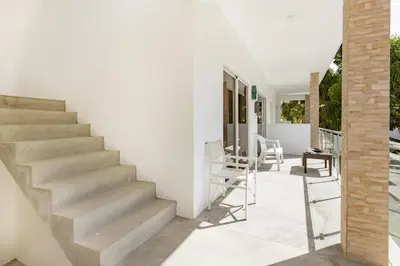 a staircase leading up to a white house with chairs at El patio de Lucia, center 4 people Las Terrenas in Las Terrenas