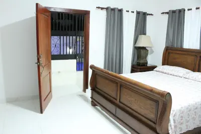 a bedroom with a bed and a wooden door at Villa luxury Cabarete in Cabarete