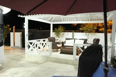a white pergola with a couch and chairs under it at Villa luxury Cabarete in Cabarete