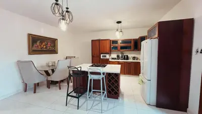 a kitchen with a table and a white refrigerator at Villa luxury Cabarete in Cabarete