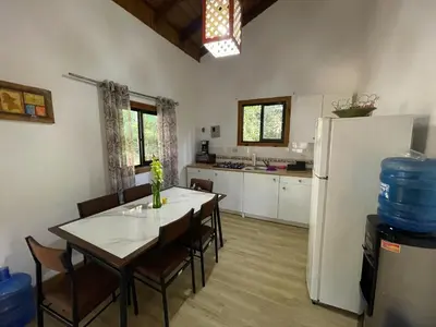a kitchen with a table and a white refrigerator at Villa Jarabacoa Monte Bonito in Jarabacoa