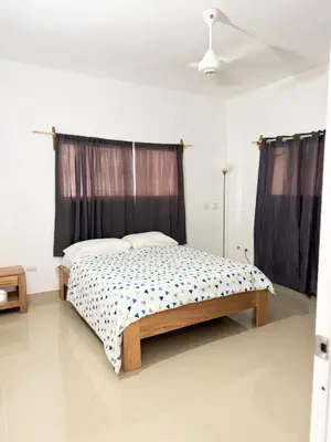a bedroom with a bed in a white room at Colina Residence in Las Terrenas