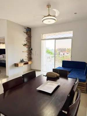 a dining room with a table and a blue couch at Colina Residence in Las Terrenas