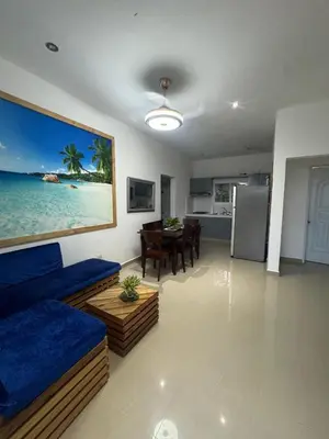 a living room with a blue couch and a table at Colina Residence in Las Terrenas