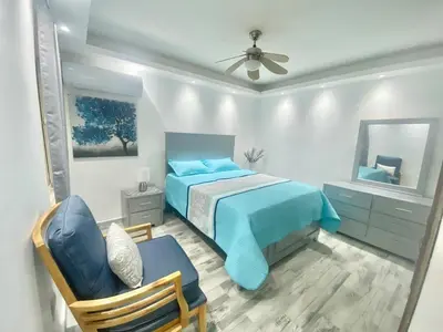 a bedroom with a blue bed and a chair at Lovely apartment colonial zone in Santo Domingo