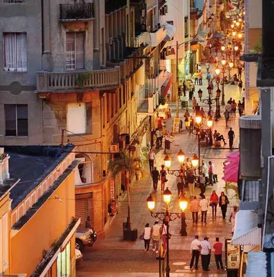 a group of people walking down a city street at night at Lovely apartment colonial zone in Santo Domingo