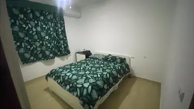 a bedroom with a bed with a green blanket at Apartamento amueblado a 5 minutos de la playa in Bayahibe