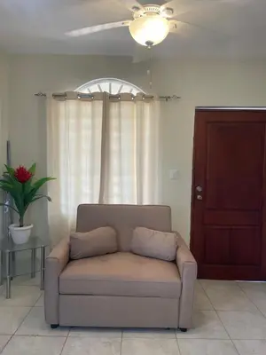 a couch in a living room with a ceiling fan at Furnished apartment available in La Romana