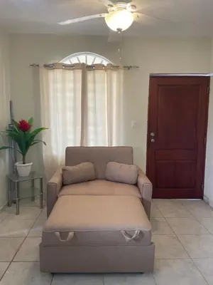 a couch in a living room with a ceiling fan at Furnished apartment available in La Romana