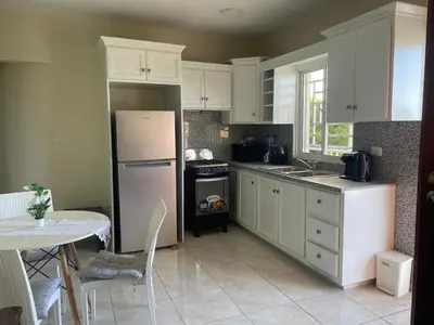 a kitchen with white cabinets and a white refrigerator at Furnished apartment available in La Romana