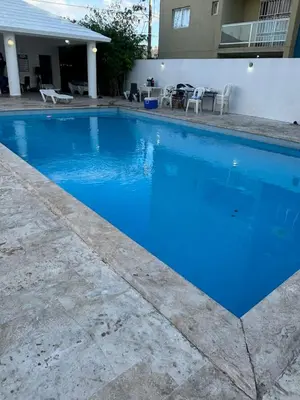 a large blue swimming pool in front of a house at Apartamento en Caleta, La Romana in La Romana