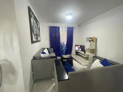 a living room with a couch and blue pillows at Apartamento en Caleta, La Romana in La Romana