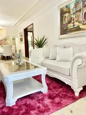 a living room with a white couch and a table at Casa con piscina Romana del Oeste in La Romana