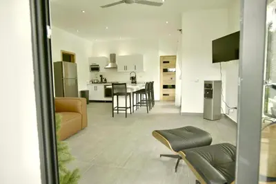 a living room and kitchen with a couch and chairs at Best Friends Hoyo Cacao in Las Terrenas