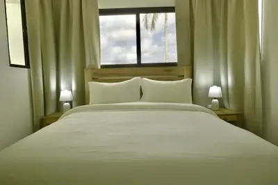 a bedroom with a large white bed with a window at Best Friends Hoyo Cacao in Las Terrenas