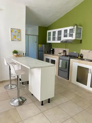 a kitchen with green walls and a white counter top at Kassuky Home in Cabarete