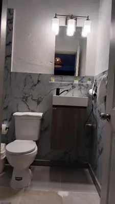 a bathroom with a toilet and a sink and a mirror at Kassuky Home in Cabarete