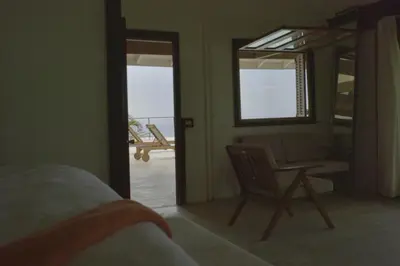 a bedroom with a chair and a table and a mirror at Villa Lukner Las Terrenas in Las Terrenas
