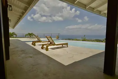 a couple of chairs sitting next to a swimming pool at Villa Lukner Las Terrenas in Las Terrenas