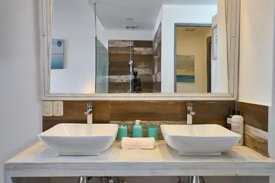 a bathroom with two white sinks and a mirror at Colonial House in Santo Domingo