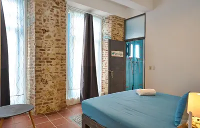 a bedroom with a blue bed and a brick wall at Colonial House in Santo Domingo