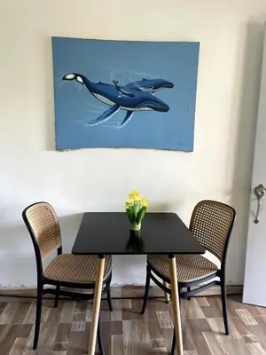 a dining room table with two chairs and a whale painting at Apartamento Dani's Guest House con piscina in Las Galeras