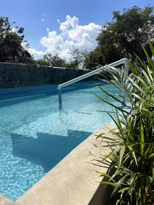 a blue swimming pool with a metal hand rail in it at Apartamento Dani's Guest House con piscina in Las Galeras