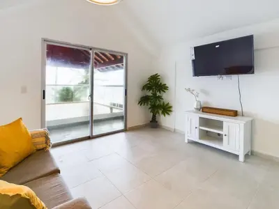 a living room with a couch and a flat screen tv at The Ocean Front Palomar in Punta Cana